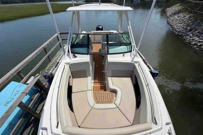 Slide: The Image of 2022 Boston Whaler 240 Vantage boat docked, featuring spacious seating and sleek design. - 8