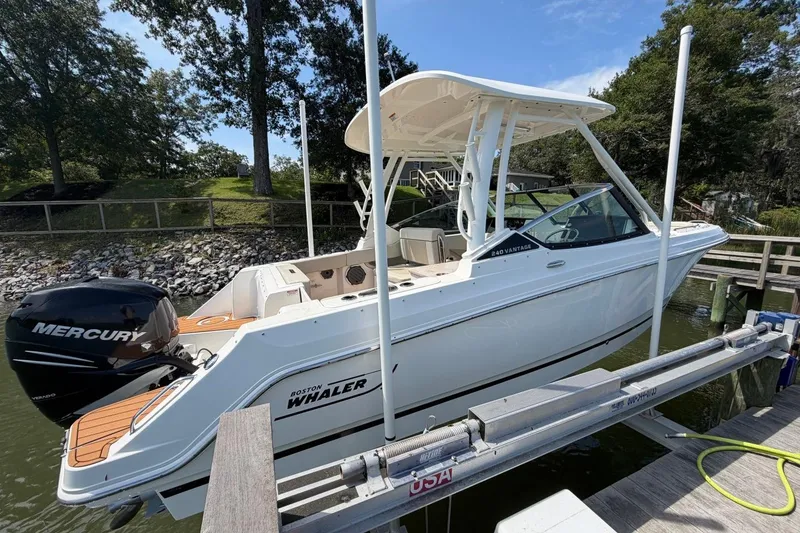 Slide: The Image of 2022 Boston Whaler 240 Vantage boat docked, featuring a Mercury outboard motor. - 5