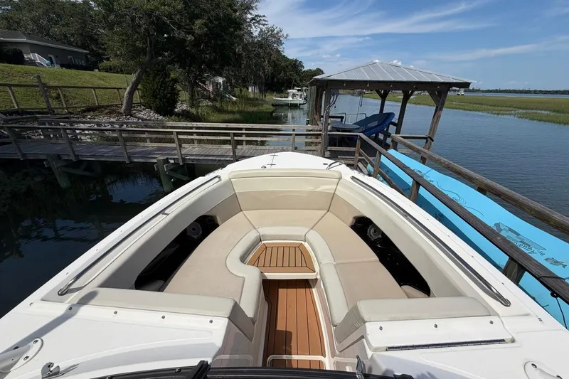 Slide: The Image of 2022 Boston Whaler 240 Vantage boat docked by a scenic waterfront. - 7