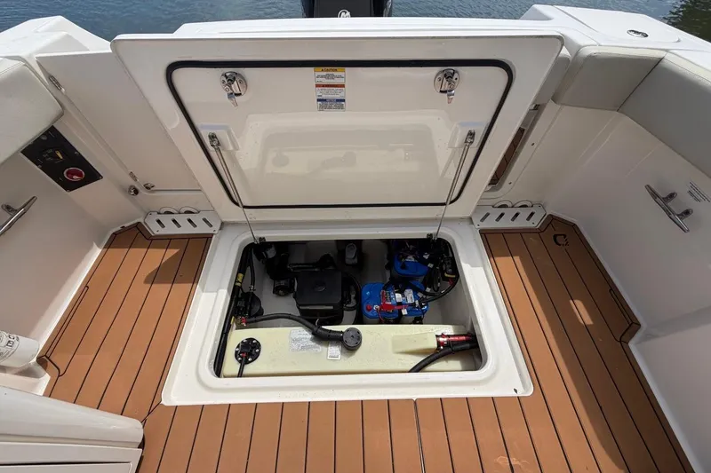 Slide: The Image of Open hatch of a 2022 Boston Whaler 240 Vantage, revealing engine compartment details. - 24