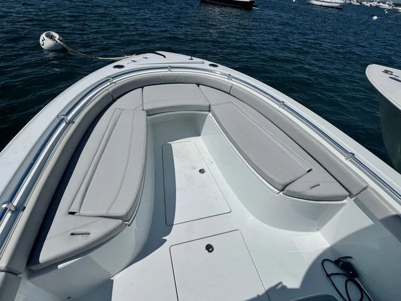 Slide: The Image of The image shows the bow area of a 2024 Contender 24 Sport boat with gray cushions. - 15