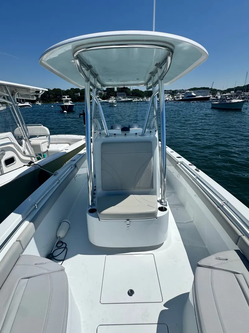 Slide: The Image of The image shows a 2024 Contender 24 Sport boat. It features an open deck with a T-top and is docked on the water. - 16