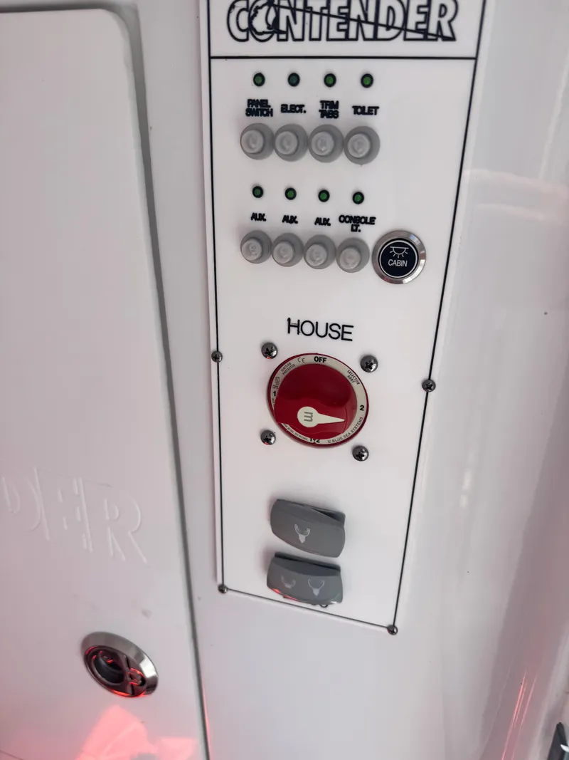 Slide: The Image of Close-up of a control panel on a 2024 Contender 24 Sport boat with switches and knobs. - 23