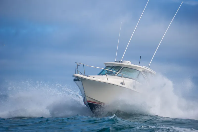 Slide: The Image of 2014 Pursuit OS 315 Offshore boat navigating through ocean waves. - 11