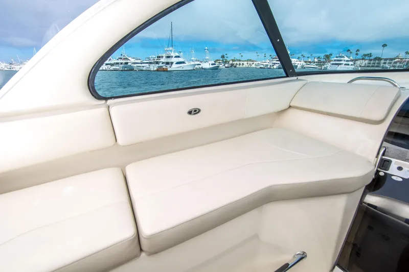 Slide: The Image of Interior view of 2014 Pursuit OS 315 Offshore boat with cream seating and marina backdrop. - 23