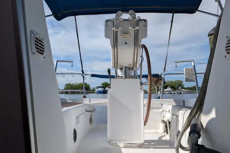 Slide: The Image of 2006 Beneteau 343 sailboat cockpit with steering wheel, docked under blue sky. - 6