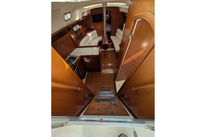 Slide: The Image of Interior of 2006 Beneteau 343 sailboat with wooden finish and cozy seating area. - 7
