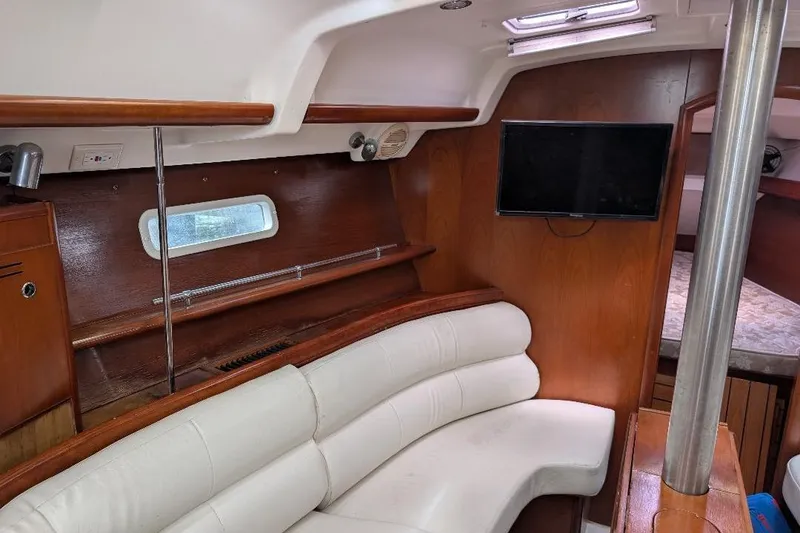 Slide: The Image of Interior of 2006 Beneteau Oceanis 352 yacht with white seating and mounted TV. - 8