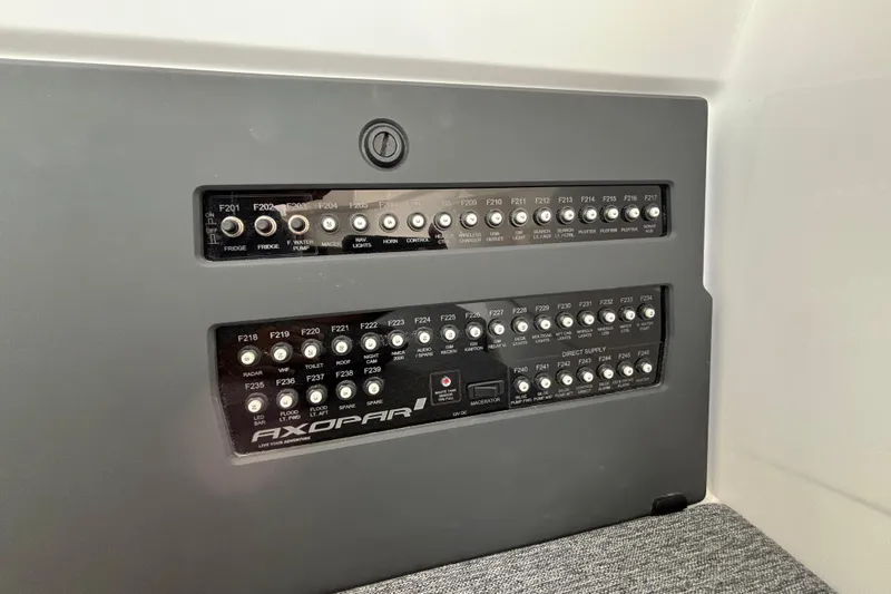 Slide: The Image of Control panel of 2025 Axopar 29 XC Cross Cabin boat, featuring labeled switches and buttons. - 28