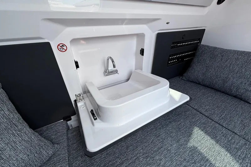 Slide: The Image of 2025 Axopar 29 XC Cross Cabin interior with compact sink and seating area. - 26