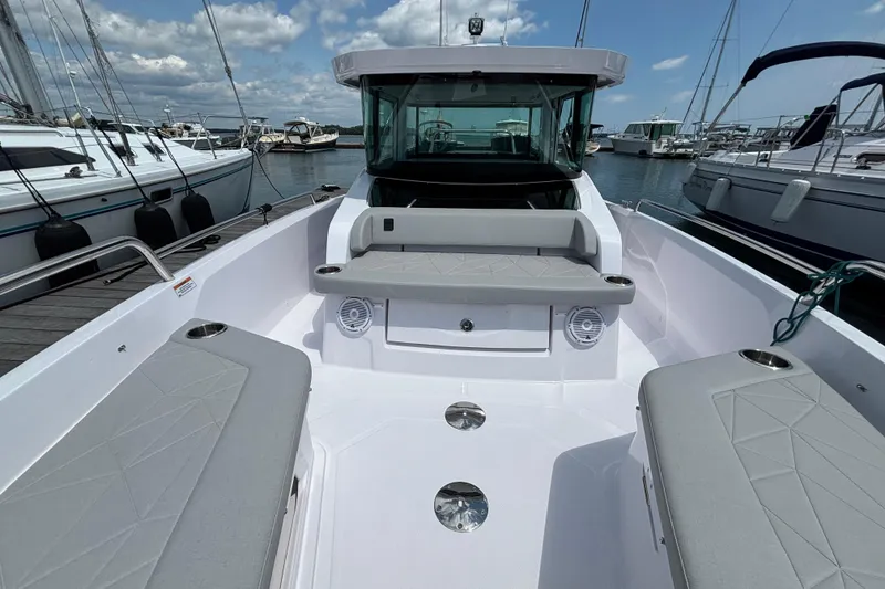 Slide: The Image of 2025 Axopar 29 XC Cross Cabin boat docked, featuring spacious seating and modern design. - 16