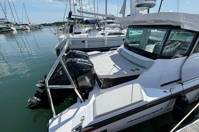 Slide: The Image of 2025 Axopar 29 XC Cross Cabin boat docked with twin Mercury engines. - 4