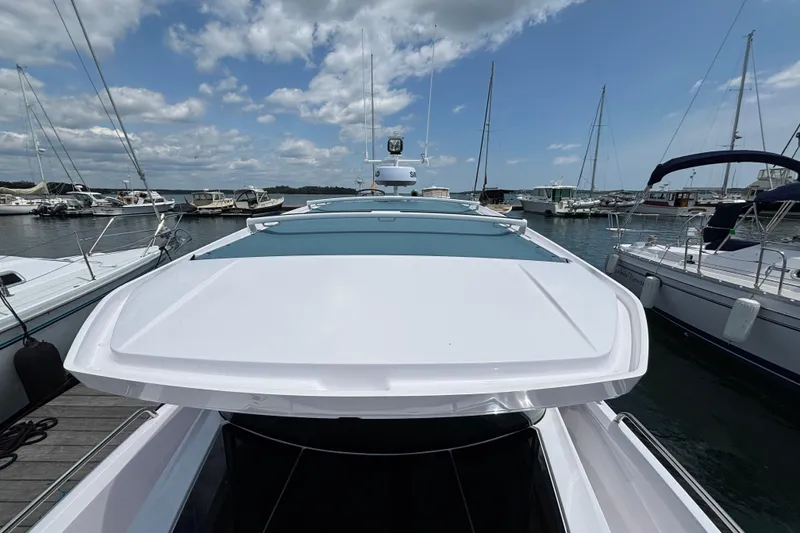 Slide: The Image of 2025 Axopar 29 XC Cross Cabin docked at a marina under a partly cloudy sky. - 17