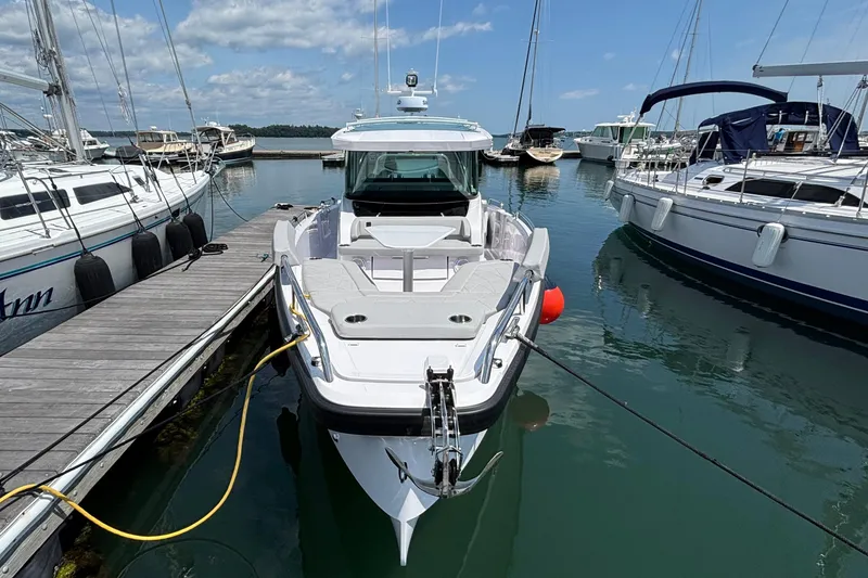Slide: The Image of 2025 Axopar 29 XC Cross Cabin docked at marina, surrounded by sailboats. - 3