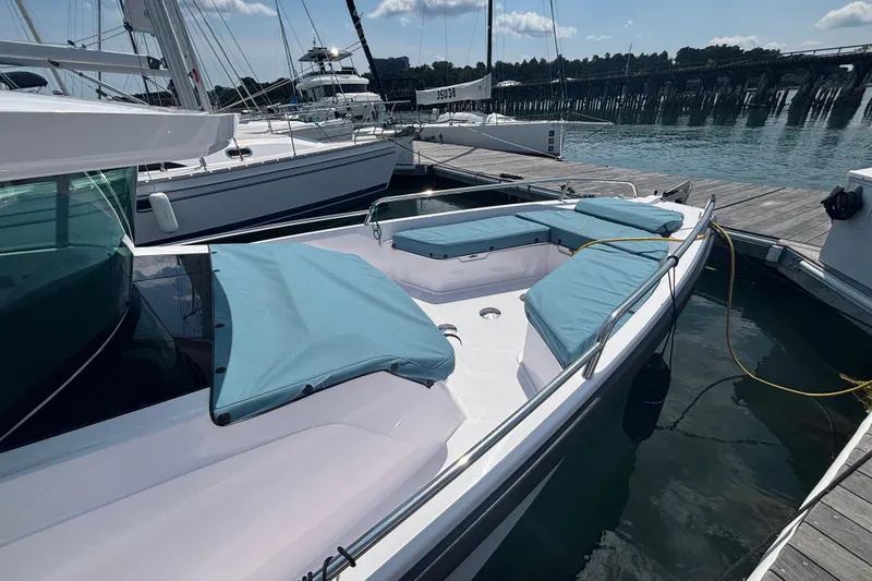 Slide: The Image of 2025 Axopar 29 XC Cross Cabin boat docked, featuring blue cushioned seating and sleek design. - 8