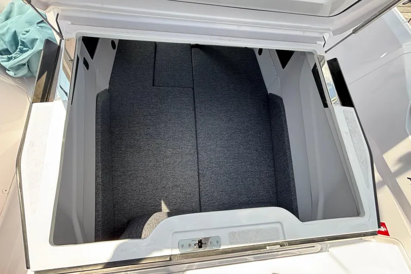 Slide: The Image of 2025 Axopar 29 XC Cross Cabin storage compartment with gray interior upholstery. - 30