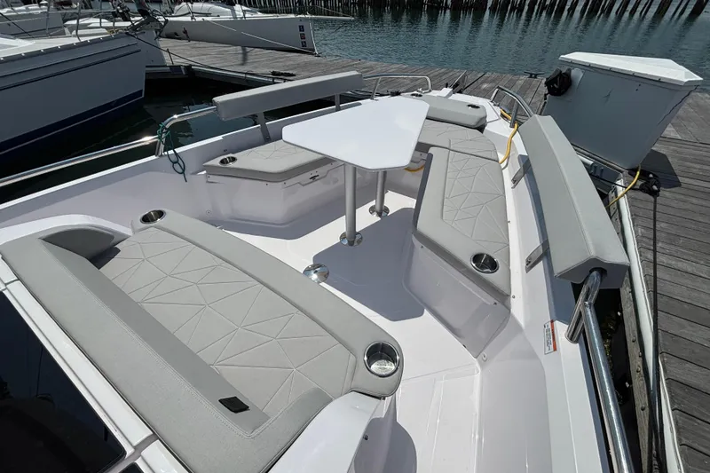 Slide: The Image of 2025 Axopar 29 XC Cross Cabin boat with spacious seating and table on deck. - 12