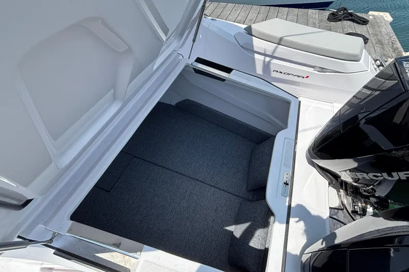 Slide: The Image of 2025 Axopar 29 XC Cross Cabin boat storage compartment, open with cushioned interior. - 29