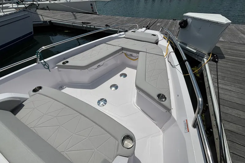 Slide: The Image of 2025 Axopar 29 XC Cross Cabin boat with cushioned seating at dock. - 11