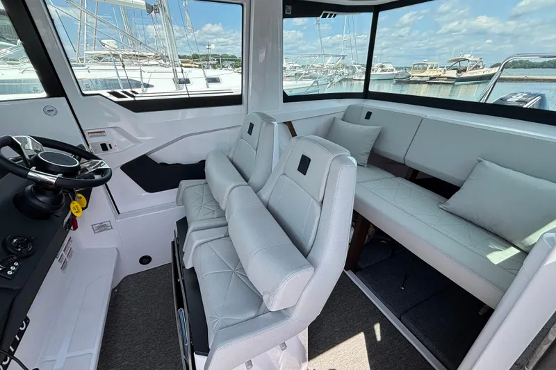 Slide: The Image of Interior of 2025 Axopar 29 XC Cross Cabin with modern seating and steering wheel. - 19