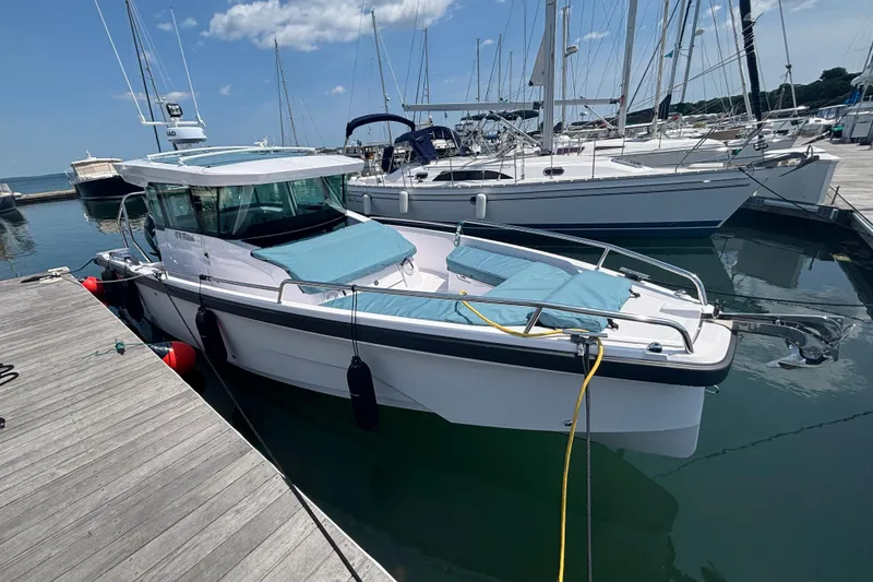 Slide: The Image of 2025 Axopar 29 XC Cross Cabin boat docked at marina under clear blue sky. - 9