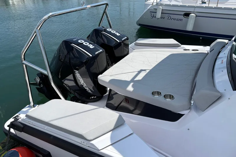 Slide: The Image of 2025 Axopar 29 XC Cross Cabin with dual Mercury outboard engines, docked in a marina. - 14