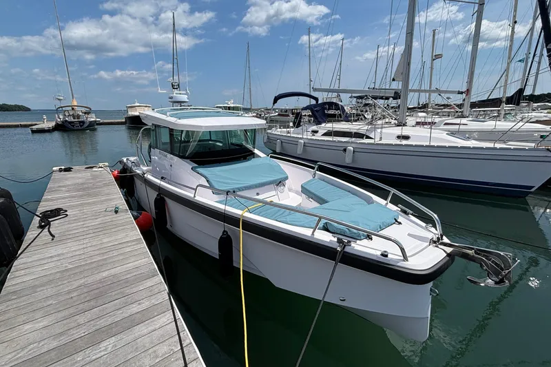 Slide: The Image of 2025 Axopar 29 XC Cross Cabin docked at marina under clear skies. - 7