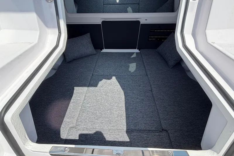 Slide: The Image of 2025 Axopar 29 XC Cross Cabin interior with gray cushions and modern design. - 24