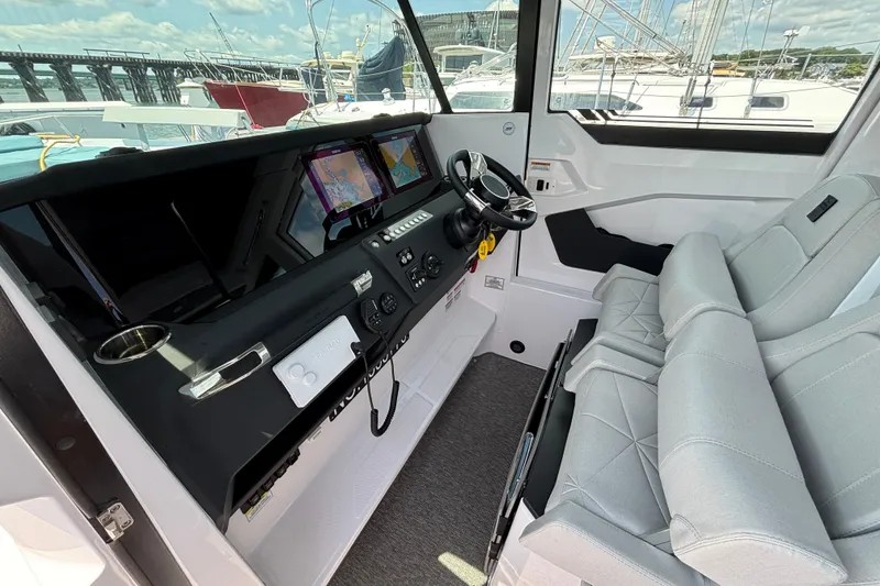 Slide: The Image of 2025 Axopar 29 XC Cross Cabin interior with modern dashboard and dual navigation screens. - 18
