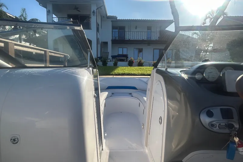 Slide: The Image of 2009 Regal 2400 Bowrider boat interior with dashboard, near waterfront home. - 30