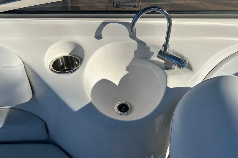 Slide: The Image of 2009 Regal 2400 Bowrider boat sink with faucet and cup holder. - 59