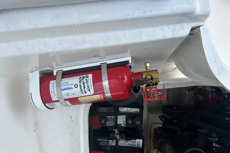 Slide: The Image of Fire extinguisher mounted on a 2009 Regal 2400 Bowrider boat, near engine compartment. - 67