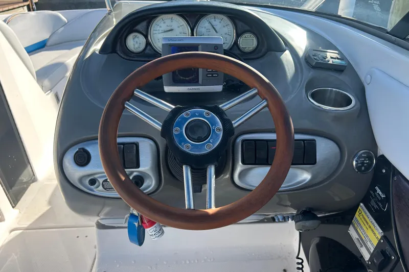 Slide: The Image of 2009 Regal 2400 Bowrider dashboard with wooden steering wheel and Garmin GPS. - 22