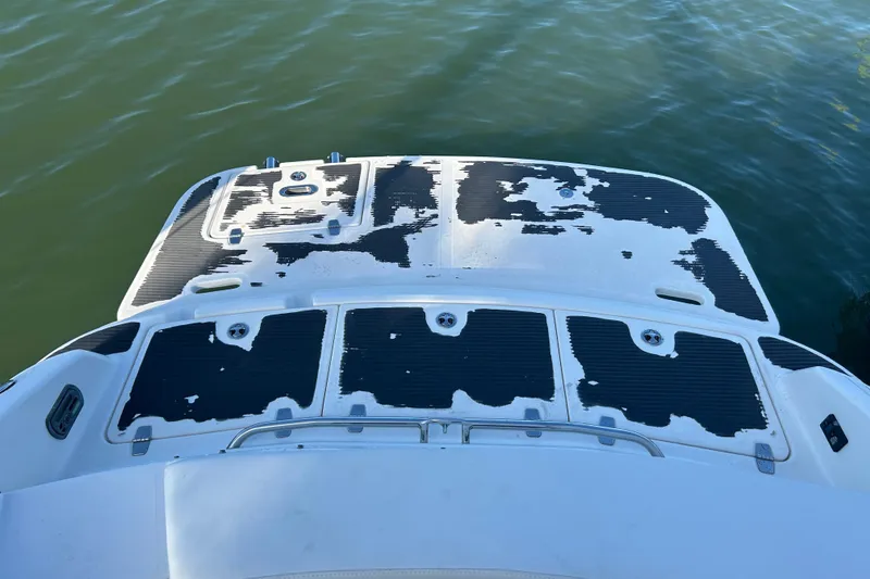 Slide: The Image of 2009 Regal 2400 Bowrider boat with worn deck pads on calm water. - 68