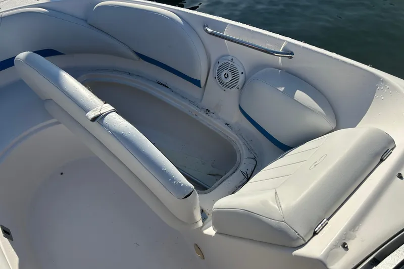 Slide: The Image of 2009 Regal 2400 Bowrider boat interior with white seating and storage compartment. - 43