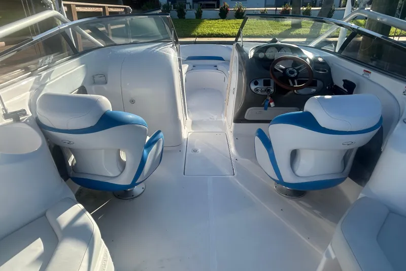 Slide: The Image of 2009 Regal 2400 Bowrider interior with white and blue seating, steering wheel, and dashboard. - 18