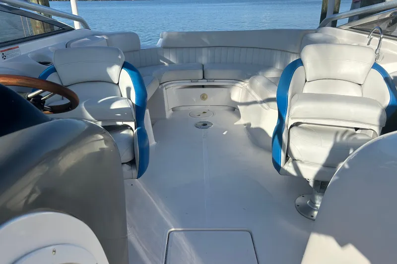Slide: The Image of 2009 Regal 2400 Bowrider interior with white and blue seating, overlooking calm waters. - 53