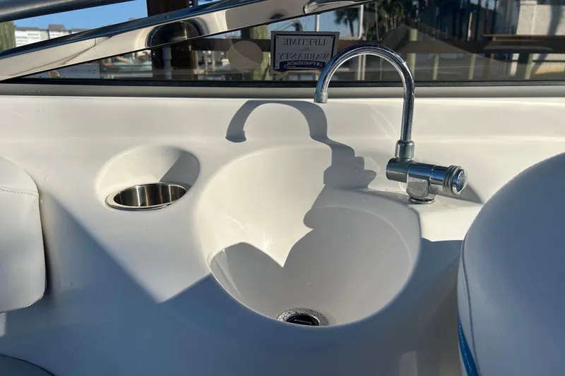 Slide: The Image of 2009 Regal 2400 Bowrider boat sink and faucet detail in sunlight. - 58