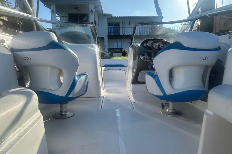 Slide: The Image of 2009 Regal 2400 Bowrider interior with blue and white seating, steering console, and open deck. - 17