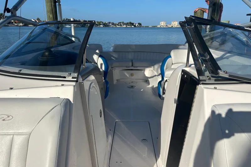 Slide: The Image of 2009 Regal 2400 Bowrider boat interior with seating, docked on calm water. - 52
