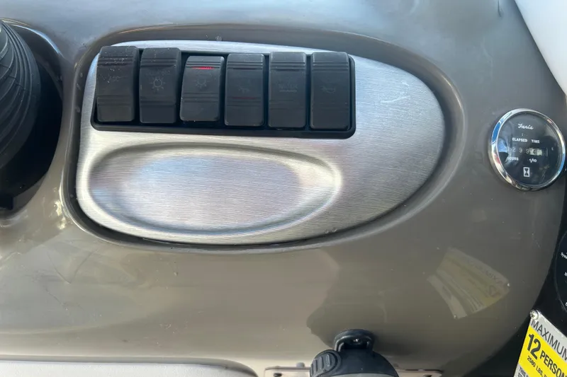 Slide: The Image of Dashboard controls of a 2009 Regal 2400 Bowrider boat, featuring switches and a gauge. - 25