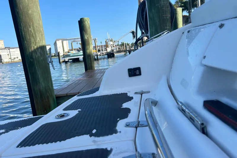 Slide: The Image of 2009 Regal 2400 Bowrider docked at marina, showing deck details and water view. - 71