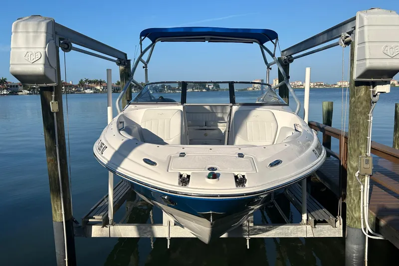 Slide: The Image of 2009 Regal 2400 Bowrider boat on lift, docked by calm waterfront. - 4