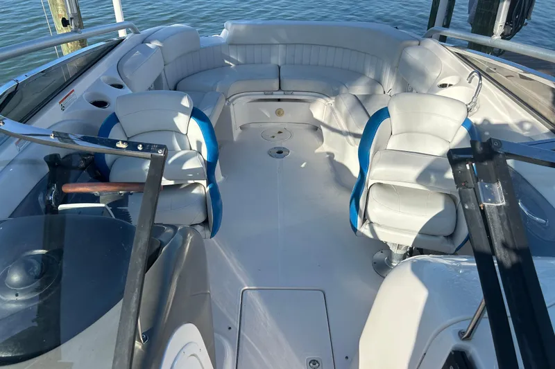 Slide: The Image of 2009 Regal 2400 Bowrider interior with white seating and blue accents on the water. - 54