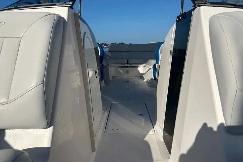 Slide: The Image of Interior view of a 2009 Regal 2400 Bowrider boat, featuring white seating and blue accents. - 51