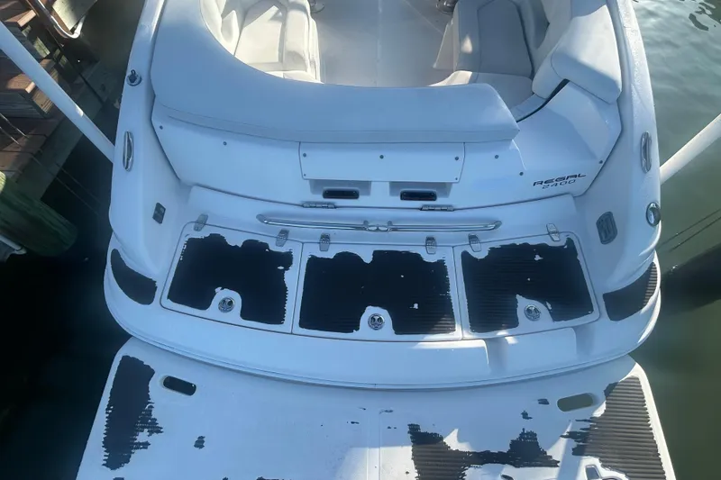 Slide: The Image of 2009 Regal 2400 Bowrider boat with worn deck pads, docked at a marina. - 13