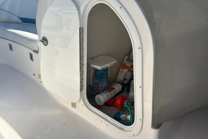 Slide: The Image of Open storage compartment on 2009 Regal 2400 Bowrider boat with various items inside. - 37