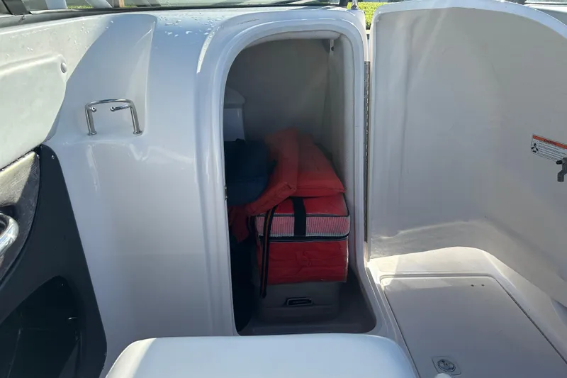 Slide: The Image of Storage compartment in a 2009 Regal 2400 Bowrider boat with life jackets. - 32