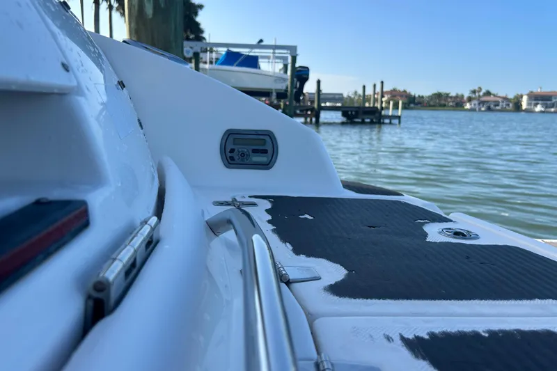 Slide: The Image of 2009 Regal 2400 Bowrider boat on calm water, showcasing deck details and scenic background. - 70