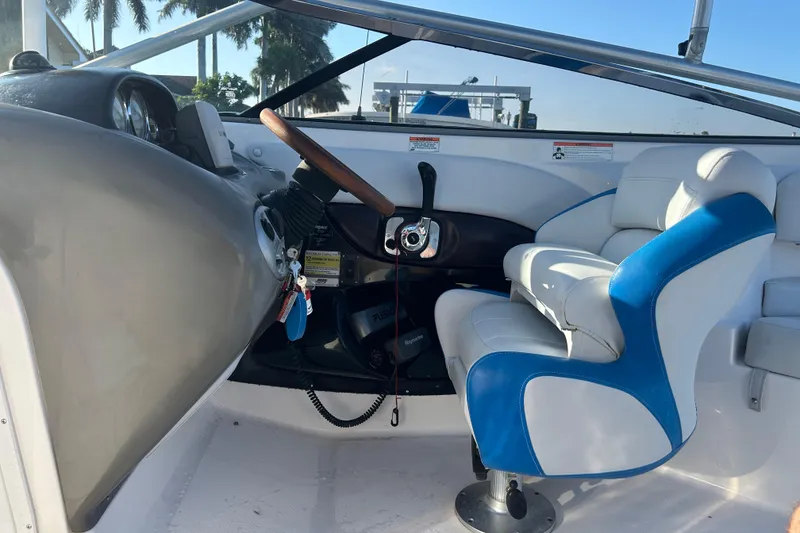 Slide: The Image of Interior of a 2009 Regal 2400 Bowrider boat with steering wheel and captain's seat. - 19